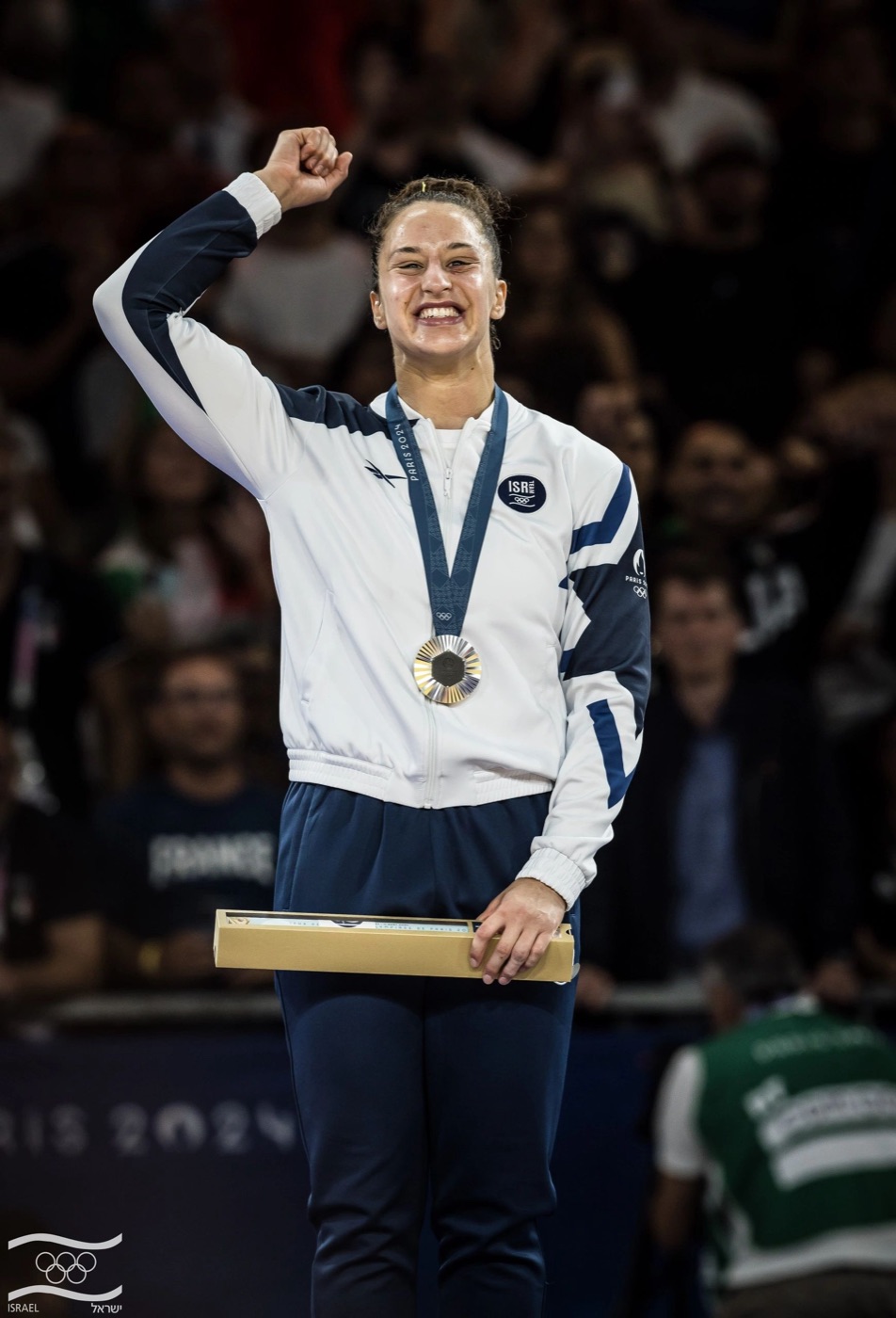 Inbar Lanir raises a fist on the Paris 2024 Olympic podium, the silver medal in the –78 kg judo category around her neck.